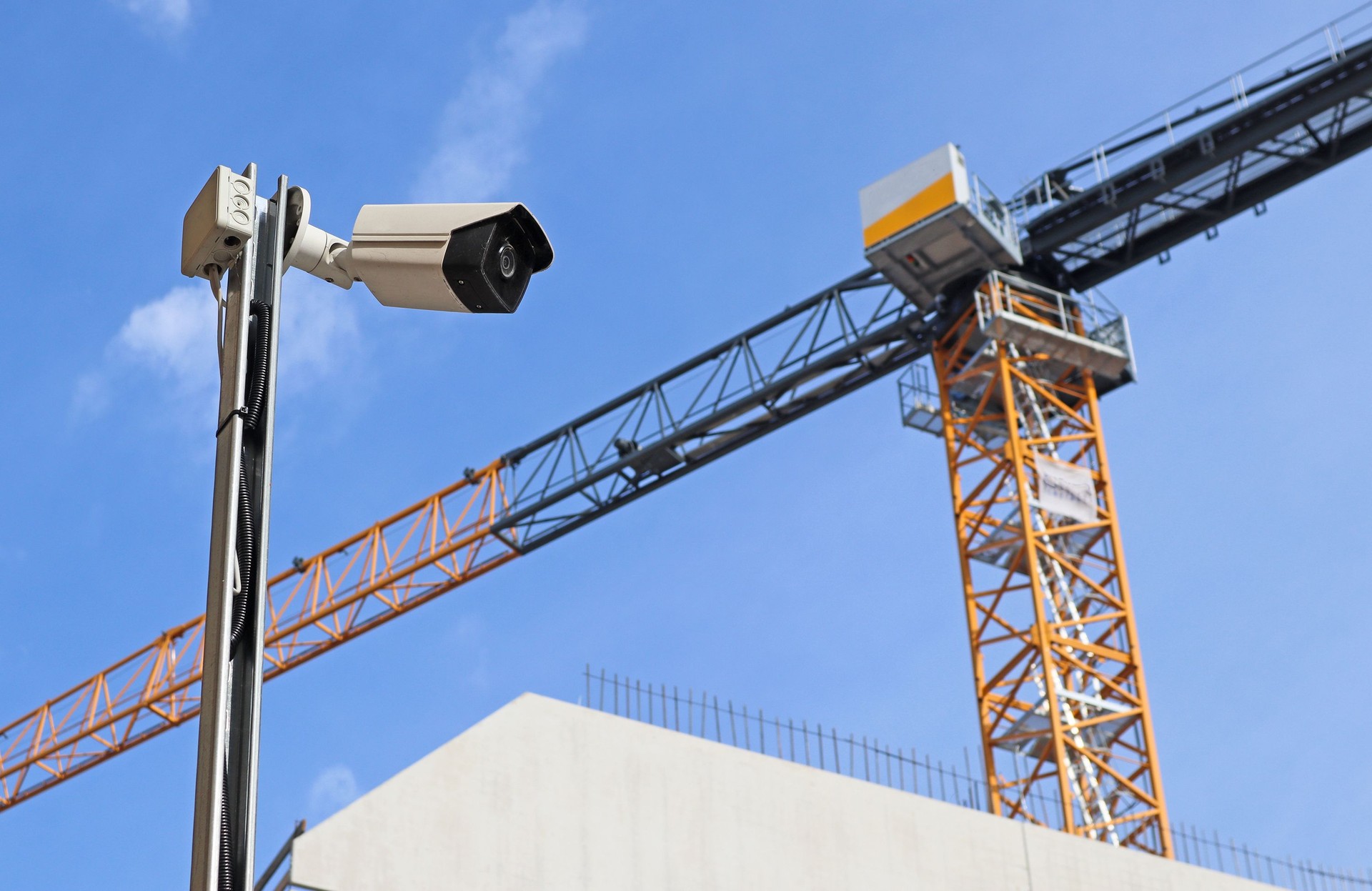 Security camera at the construction site with a tower crane