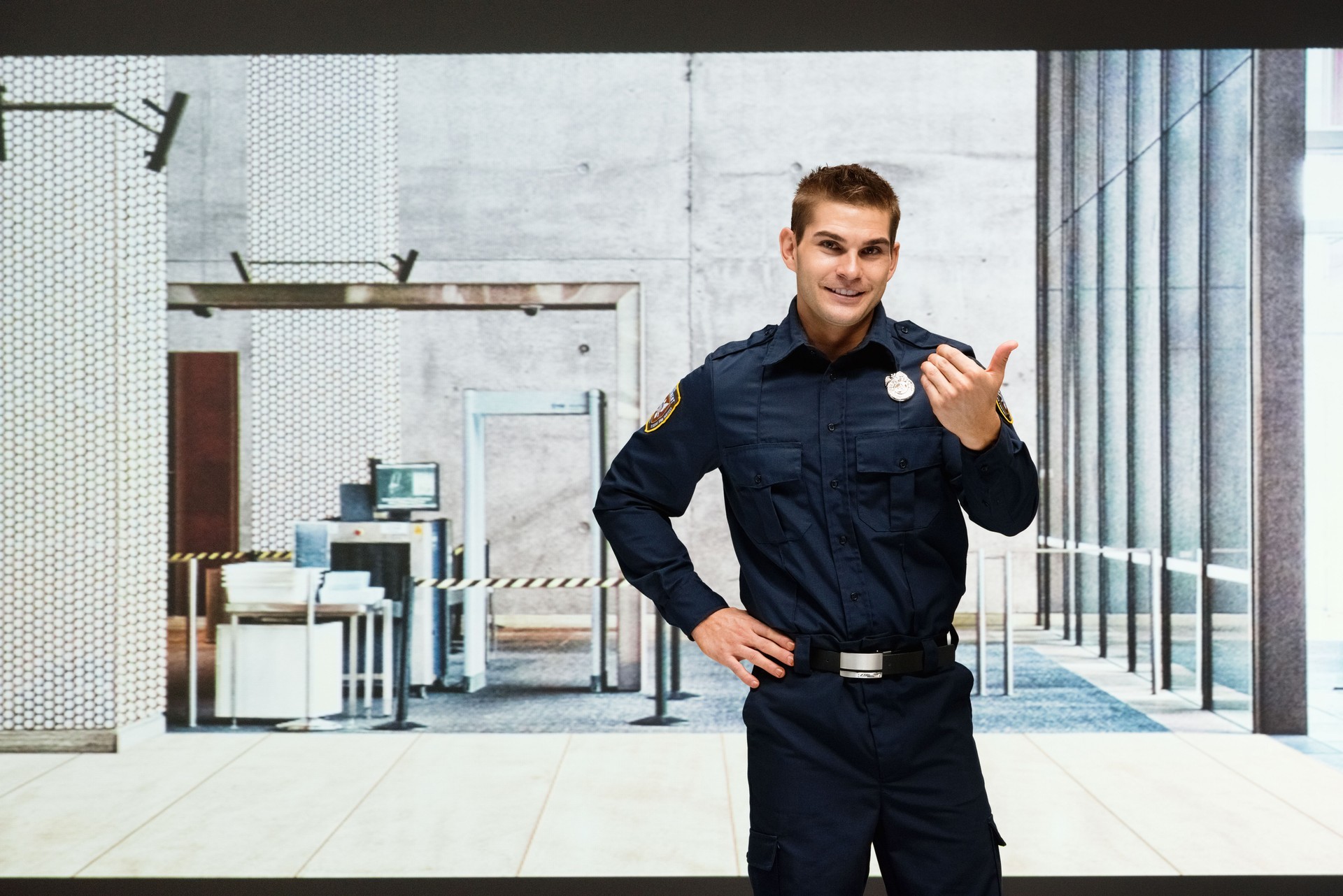 Smiling security guard gesturing indoors