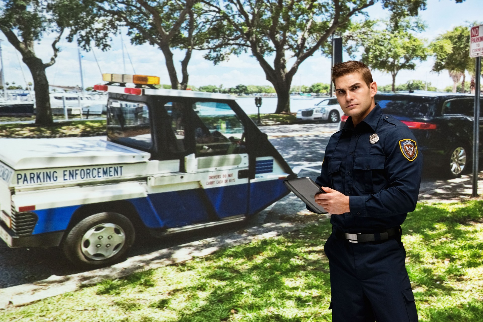 Caucasian young male security staff wearing hat and using digital tablet