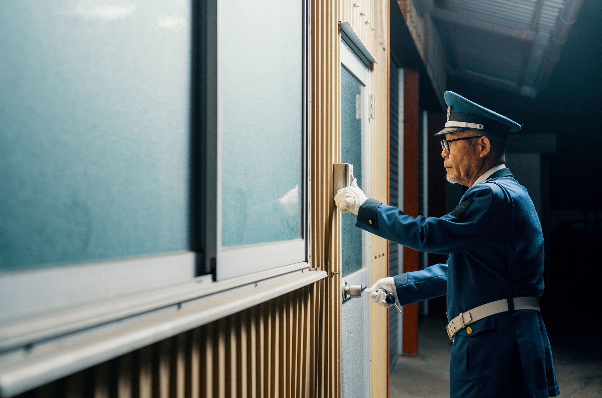 Senior male security guard unlocking a door while on duty